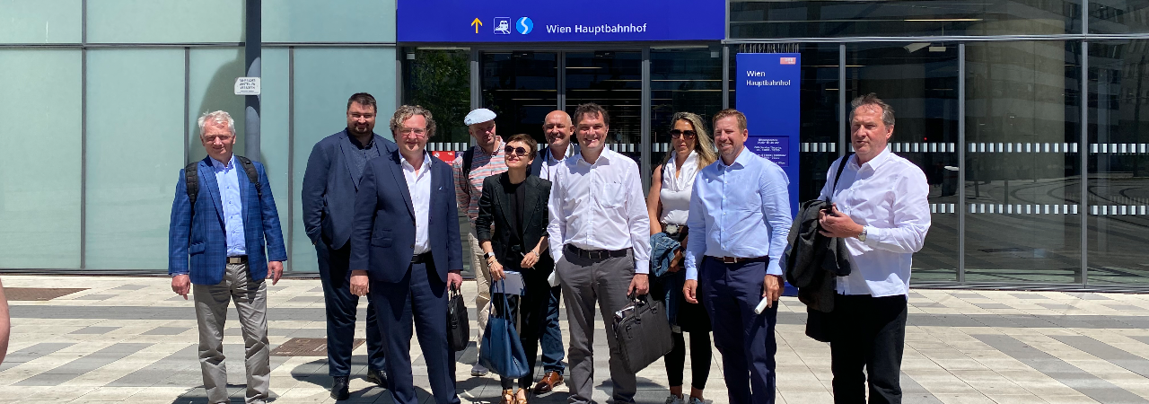 Eine Gruppe an Personen steht vor dem Eingang zum Wiener Hauptbahnhof.